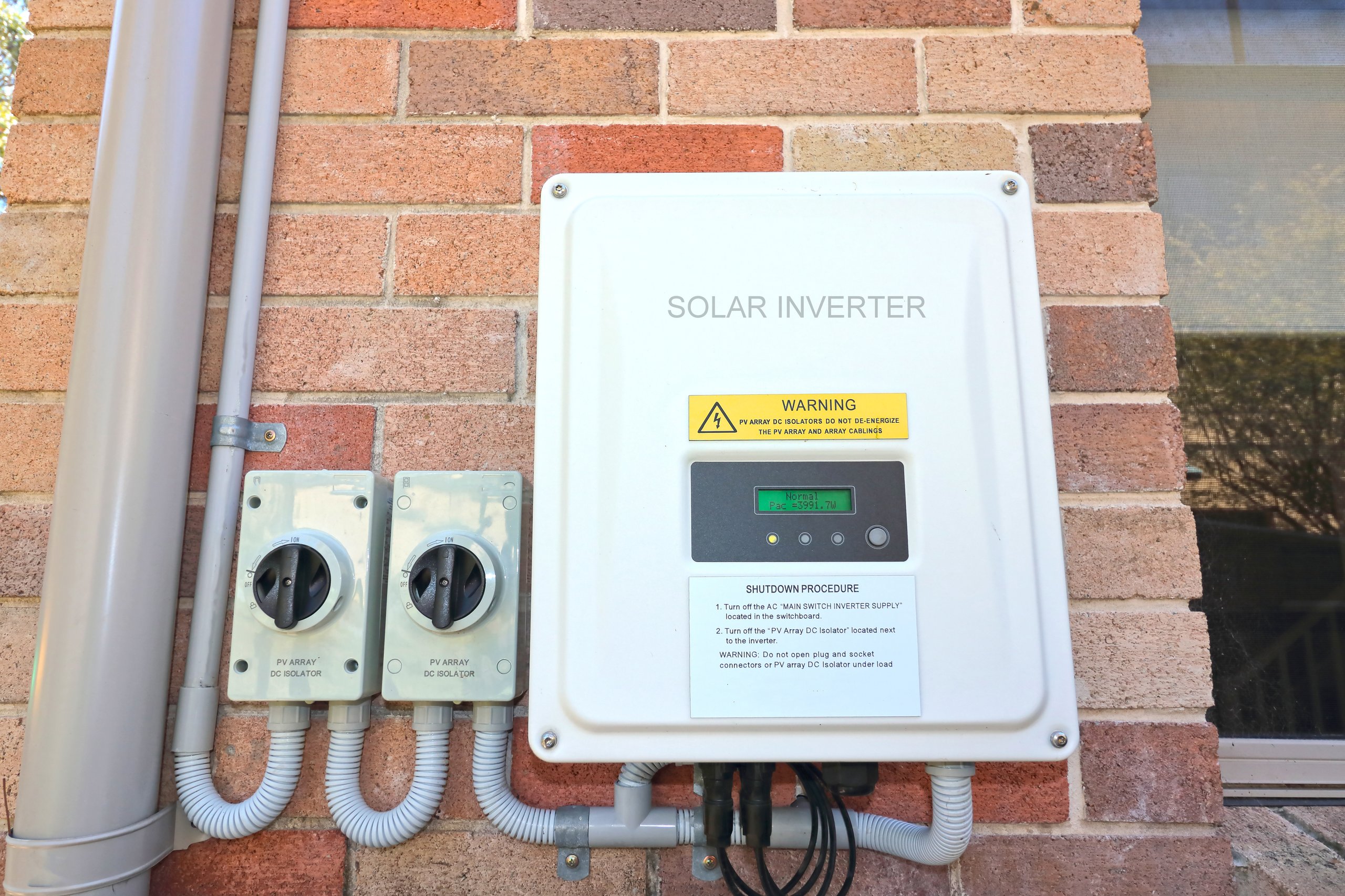 Enphase IQ8 microinverter and isolating switches on home exterior