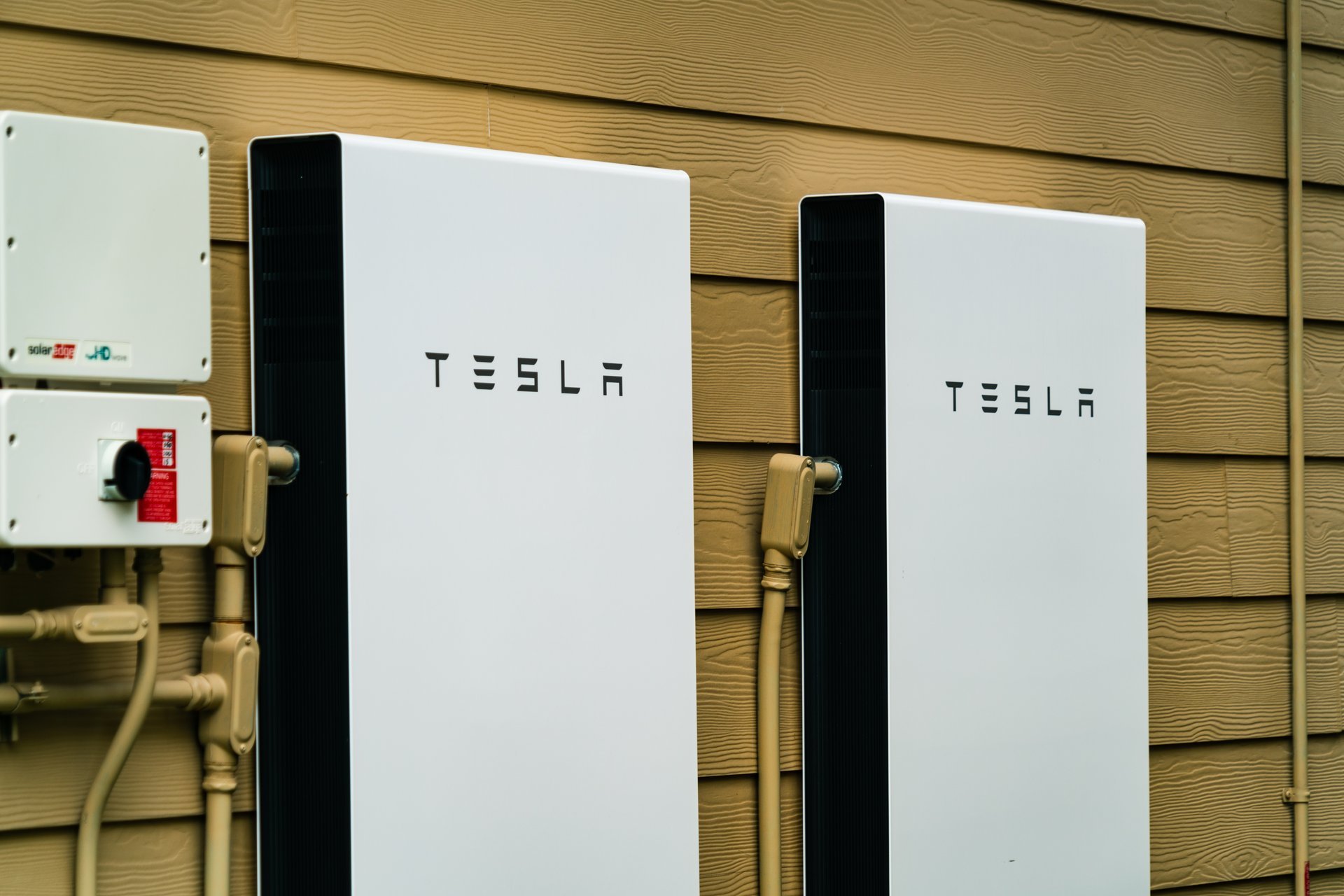 Close up on Tesla Powerwalls installed on the side of a home for solar energy storage