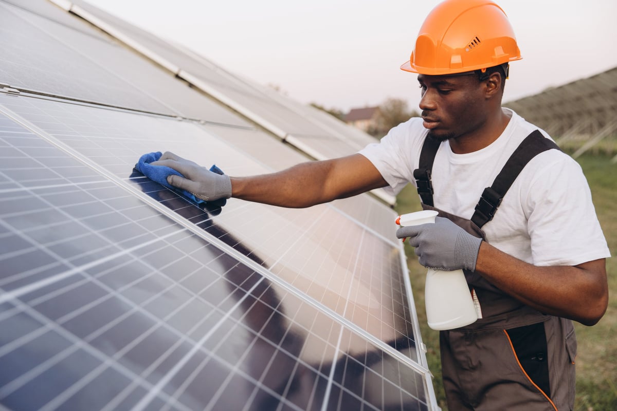 Technician skillfully cleans solar panels using professional tools to ensure optimal efficiency