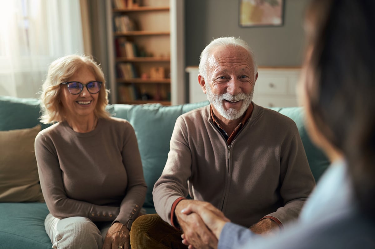 Senior couple reaching agreement with financial advisor for solar financing