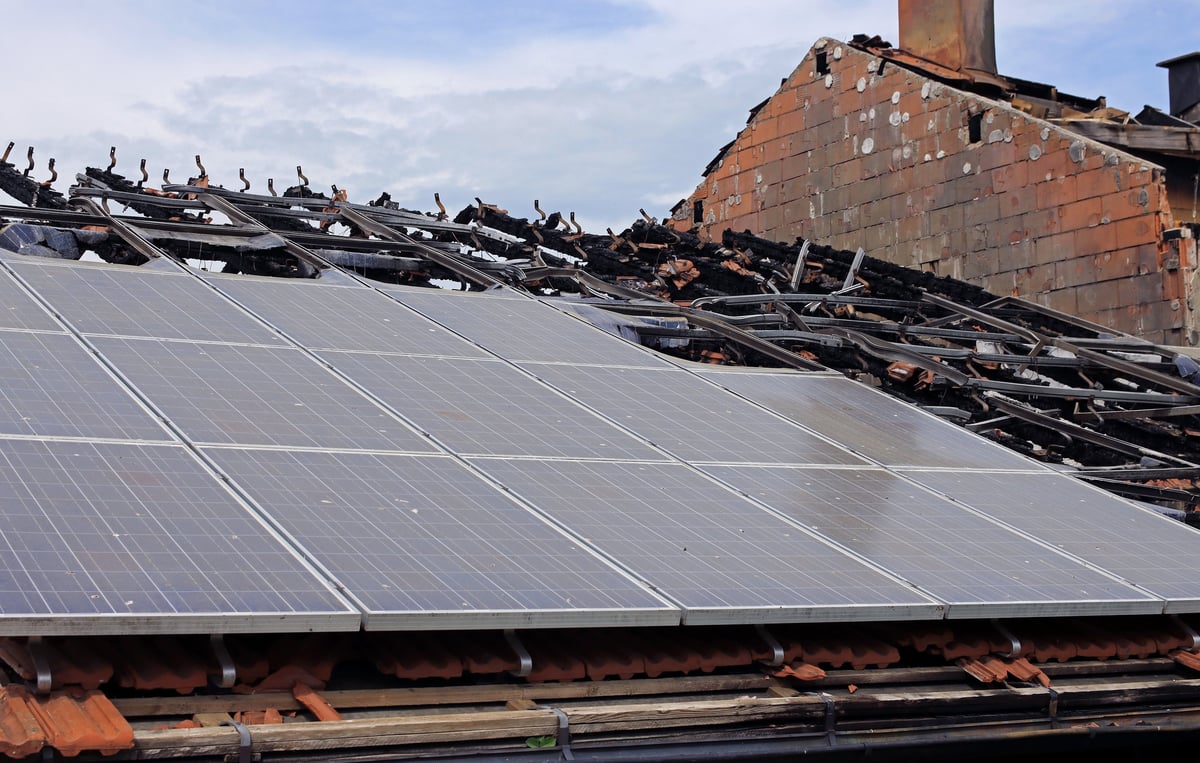 A burned-out solar panel system on a house roof. Are solar panel systems dangerous and can they cause fires?