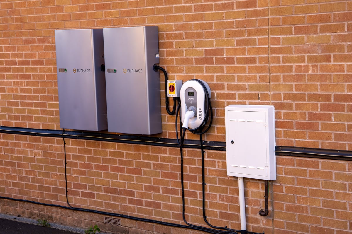 Residential wall-mounted energy storage battery units installed on an exterior brick wall